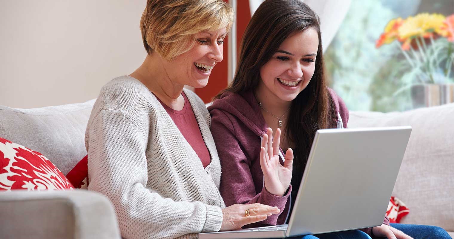Mother and teenage daughter on a video call on a laptop computer.