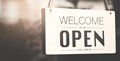 Welcome sign on door with message, "welcome we are open."
