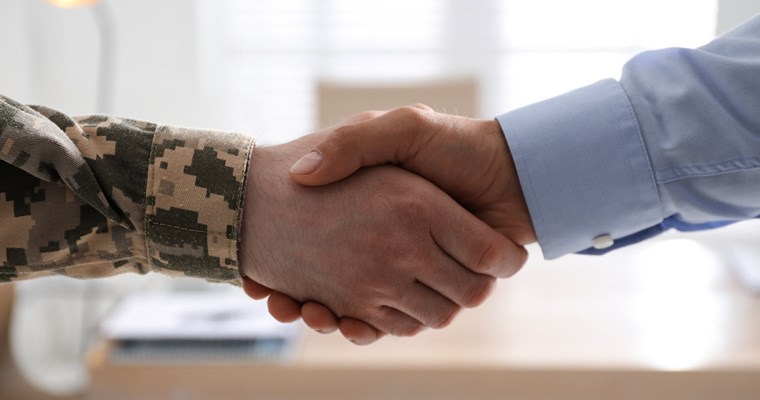 military personnel shaking hands with business professional