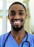 Male nurse smiles at camera with stethoscope around his neck.