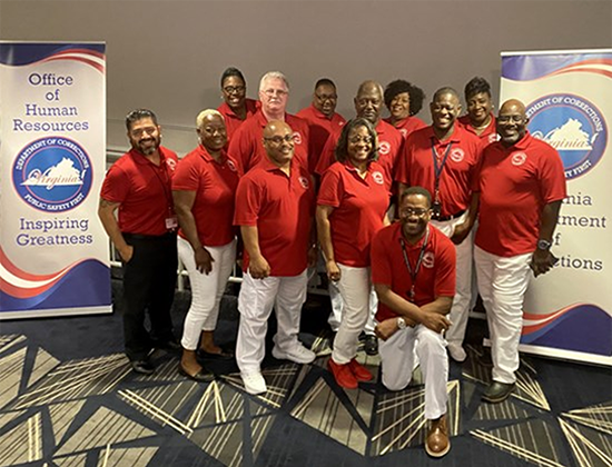 Virginia Department of Corrections HR staff all wearing red shirts smiling at camera.