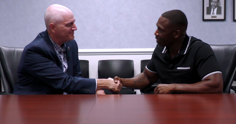 Director Dotson and Travis May shaking hands.