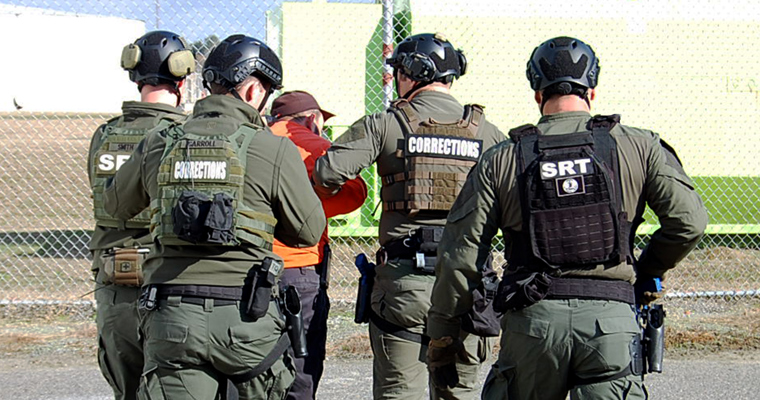 Four correctional officers escorting a man away during an active shooter drill at Greensville Correctional Center